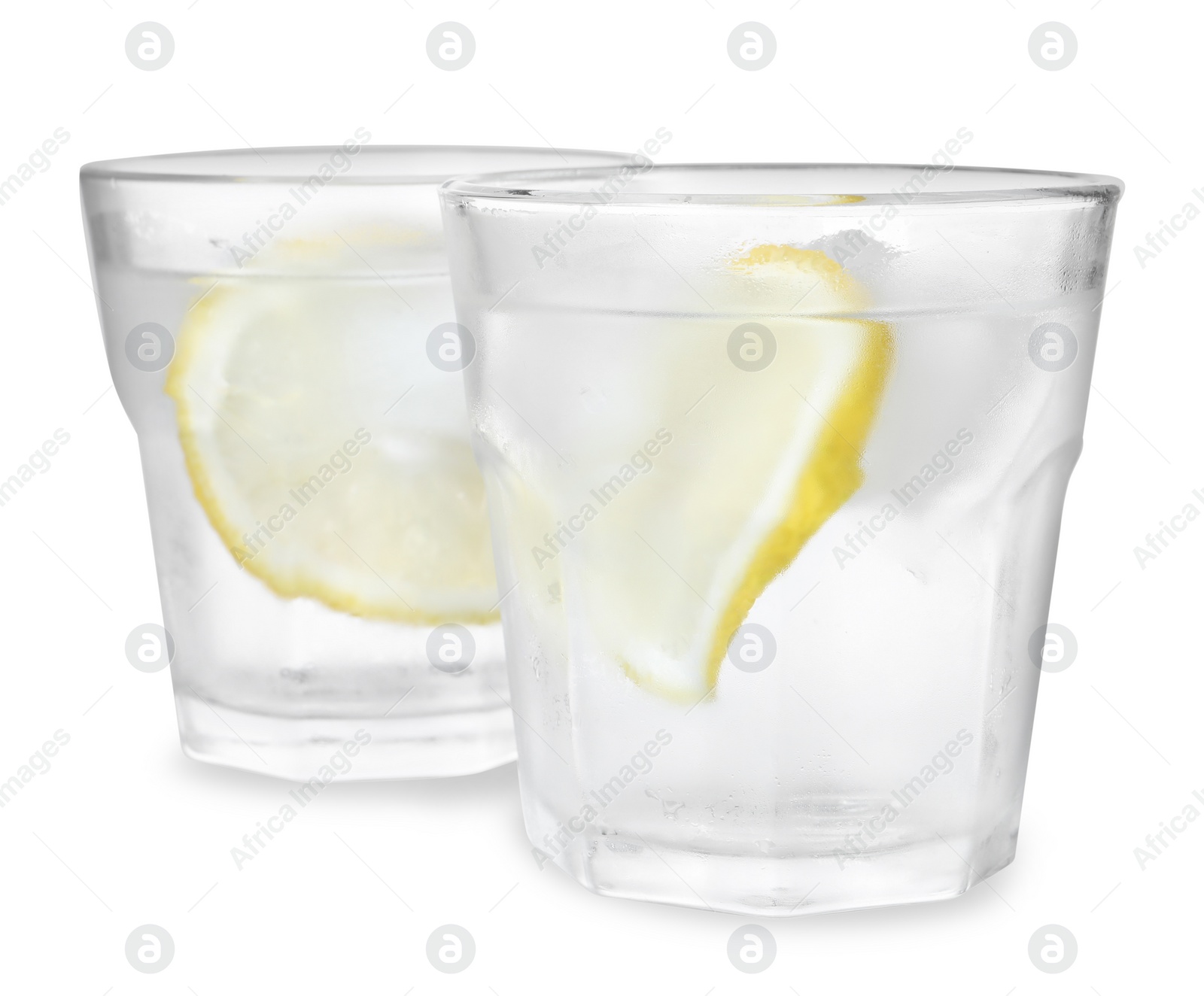 Photo of Glasses of vodka with ice and lemon isolated on white