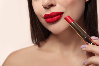 Woman with red lipstick on light background, closeup