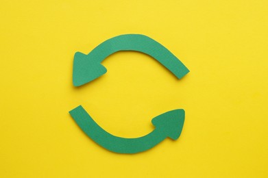 Photo of Paper curved arrows on yellow background, flat lay. Space for text