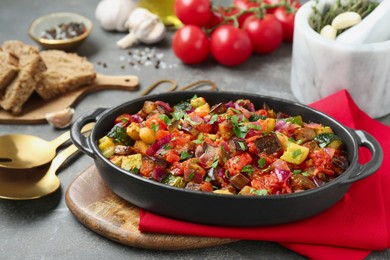 Photo of Dish with tasty ratatouille on grey textured table