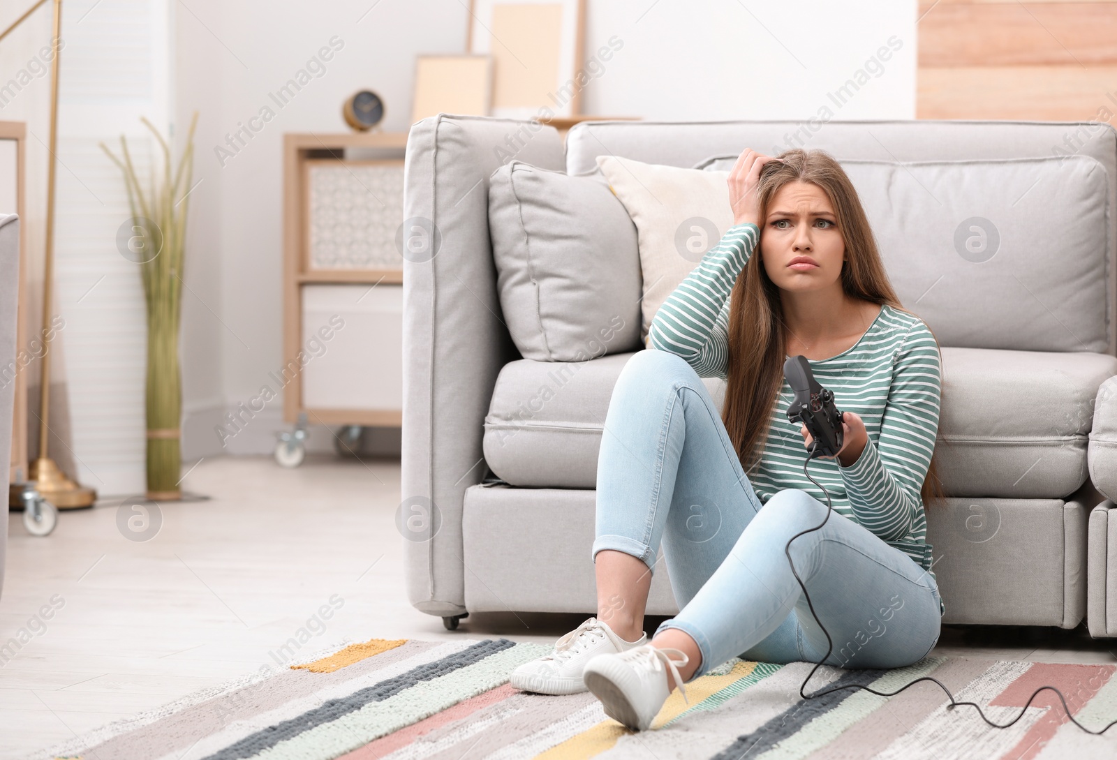 Photo of Emotional young woman playing video games at home