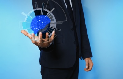 Image of Businessman holding digital image of brain in hand on blue background, closeup Machine learning concept 