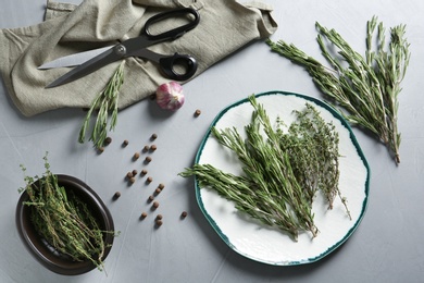 Flat lay composition with rosemary and thyme on gray background. Aromatic herbs