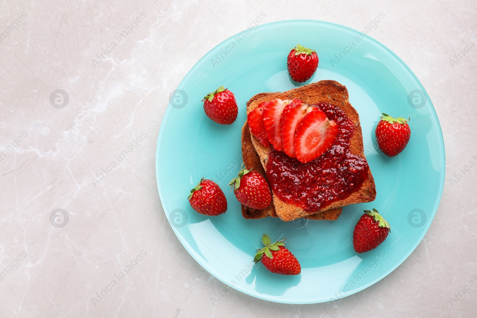 Photo of Toasts with jam and strawberries on light grey marble table, top view. Healthy breakfast
