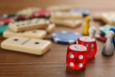 Photo of Elements of different board games on wooden table, closeup