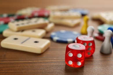 Elements of different board games on wooden table, closeup