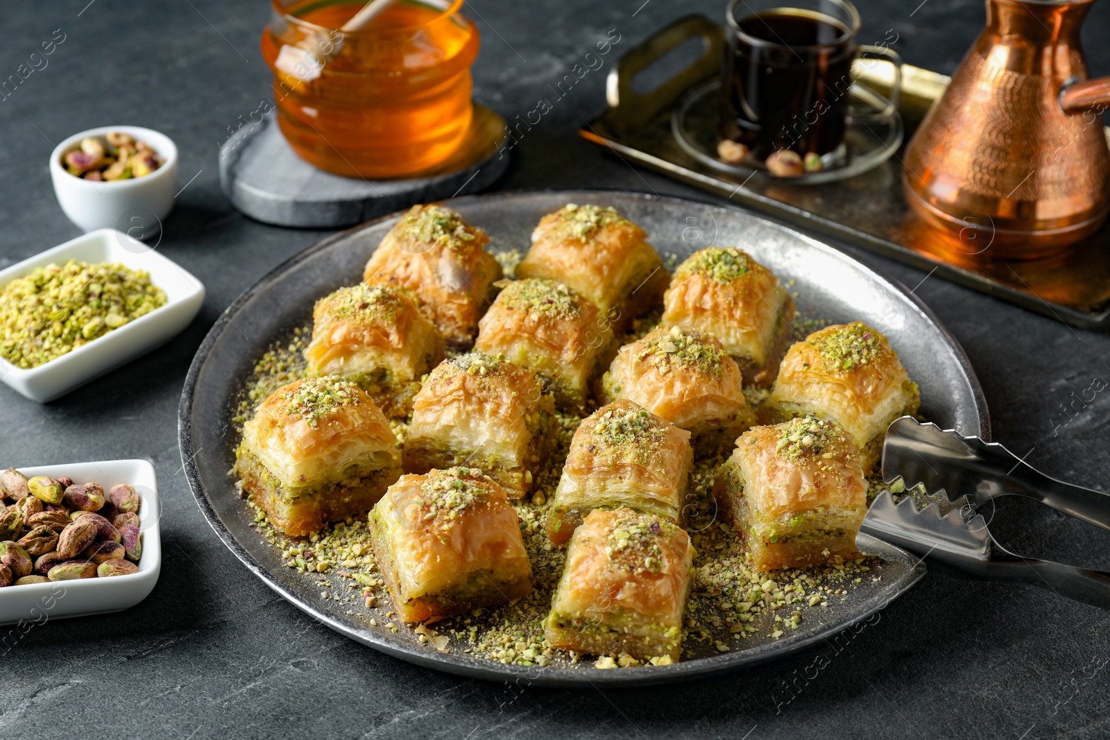 Photo of Delicious fresh baklava with chopped nuts served on grey table. Eastern sweets