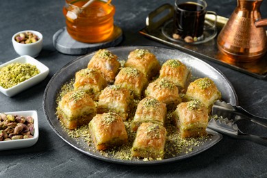 Photo of Delicious fresh baklava with chopped nuts served on grey table. Eastern sweets