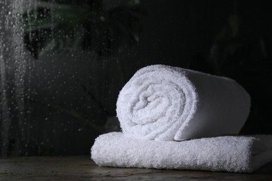 White terry towels on table in bathroom, space for text