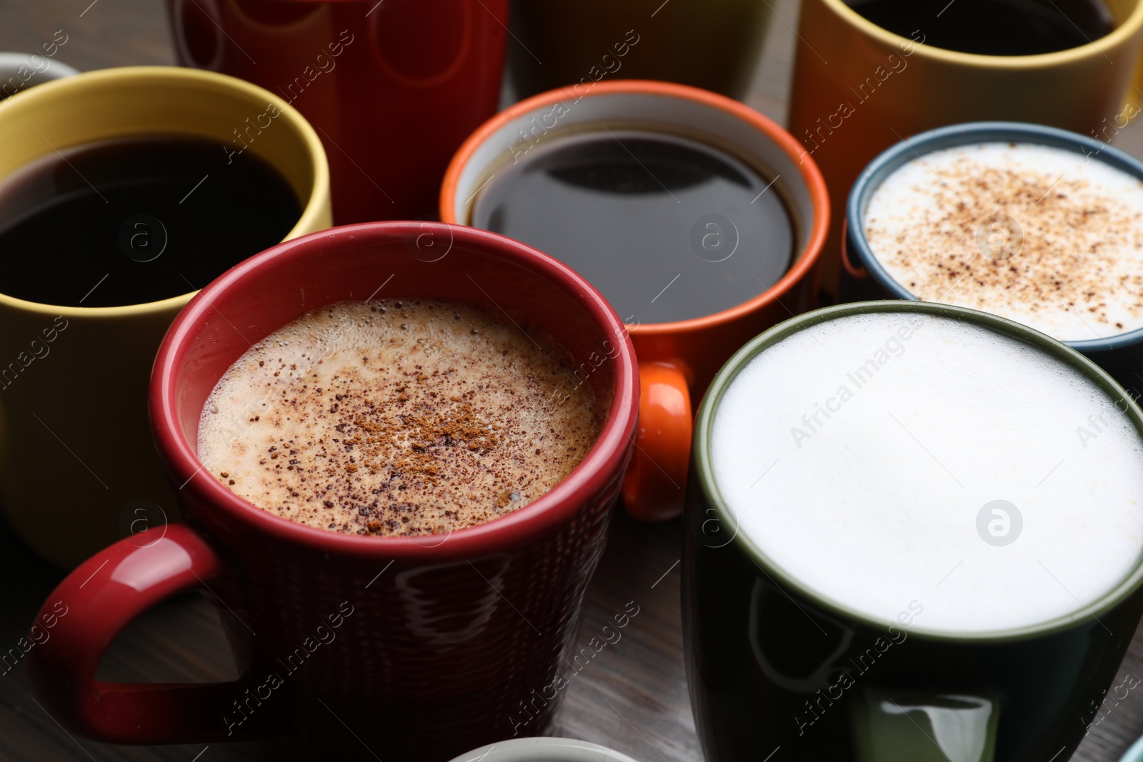 Photo of Many different cups with aromatic hot coffee on table, closeup