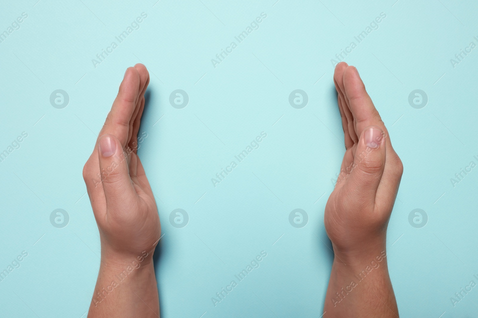 Photo of Woman holding on turquoise background, closeup of hands. Space for text