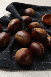 Photo of Roasted edible sweet chestnuts on light table, closeup