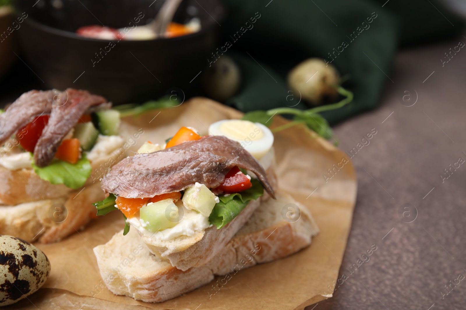 Photo of Delicious bruschettas with anchovies, eggs, cream cheese, tomatoes, bell peppers and cucumbers on grey table, space for text