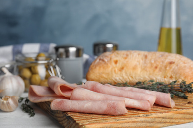 Slices of tasty ham on white wooden table