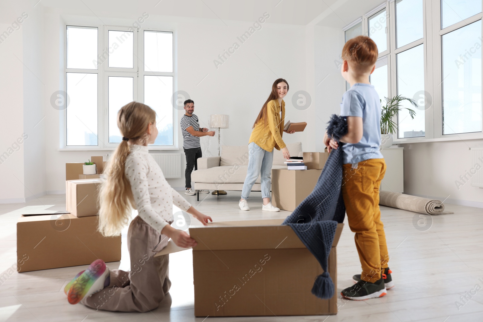 Photo of Happy family settling into new house and unpacking boxes. Moving day