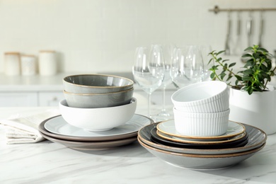 Photo of Set of beautiful tableware on white table in kitchen