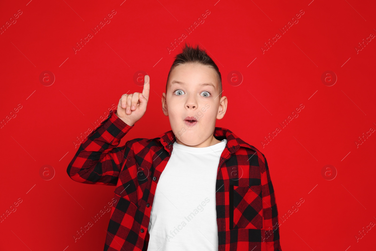 Photo of Portrait of emotional little boy on red background