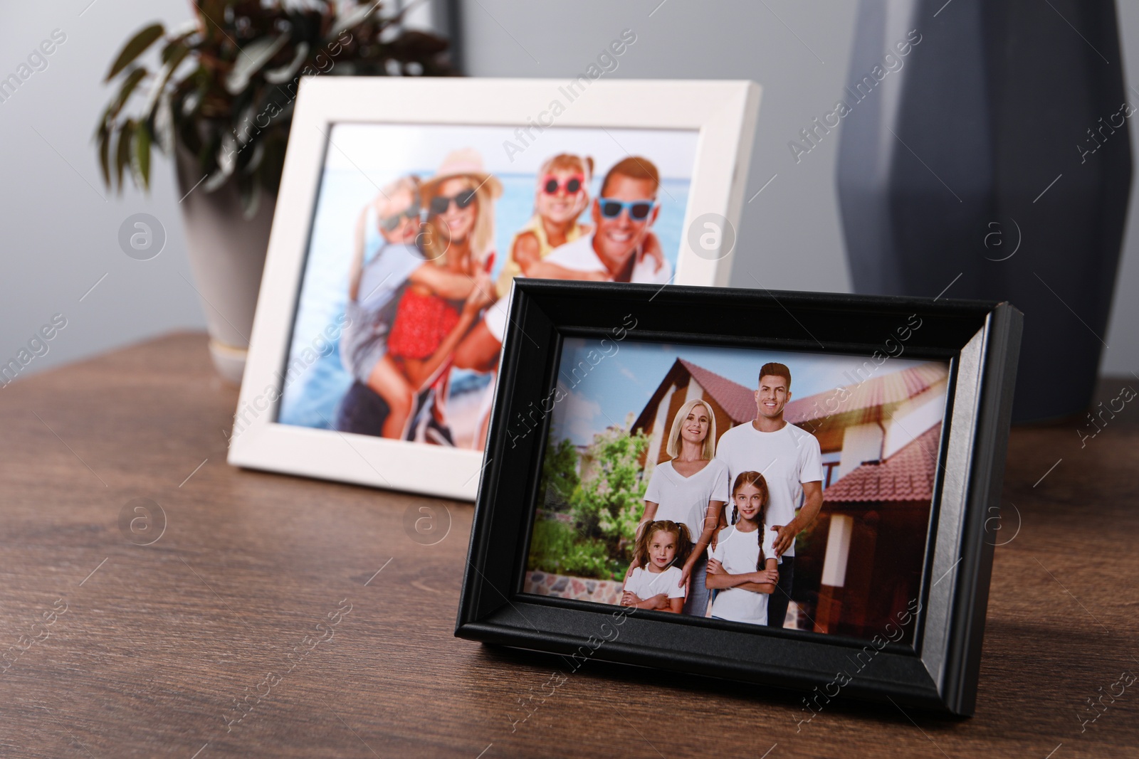 Photo of Frames with family photos on wooden table indoors