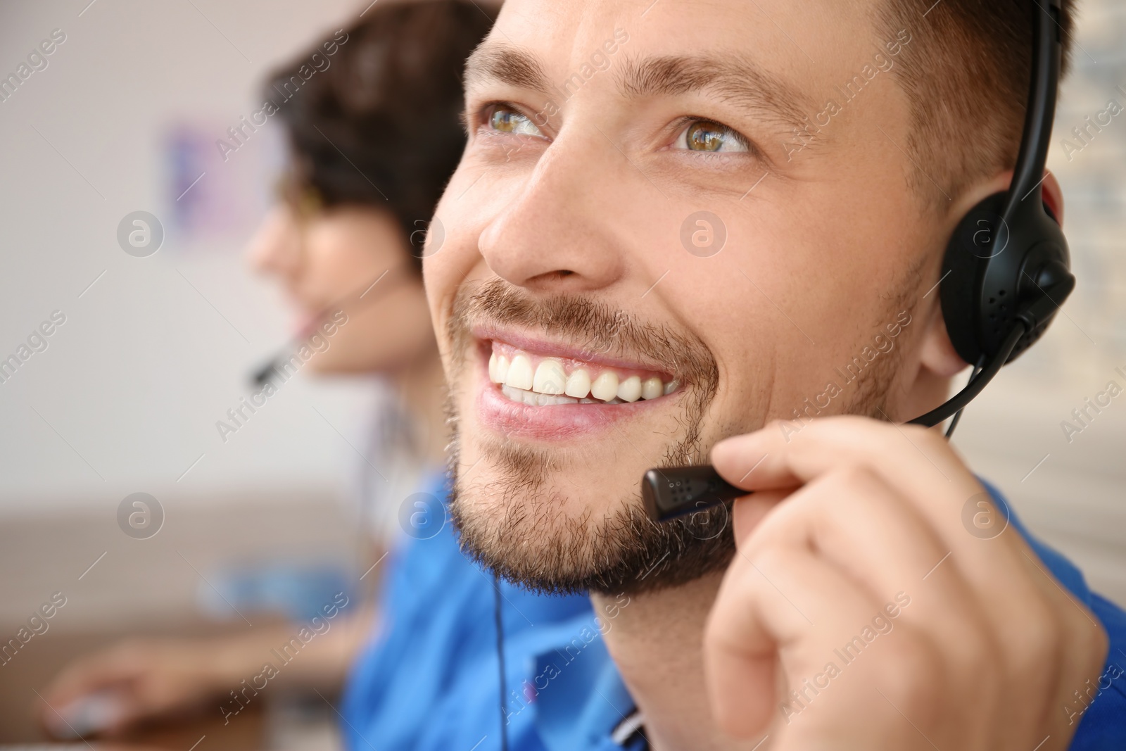 Photo of Male technical support operator with headset at workplace