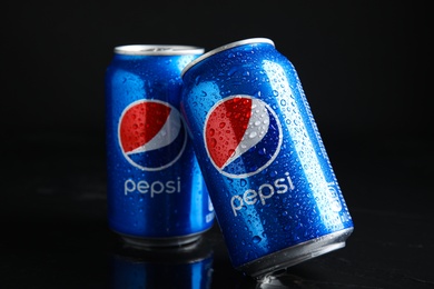 Photo of MYKOLAIV, UKRAINE - FEBRUARY 08, 2021: Cans of Pepsi with water drops on black table