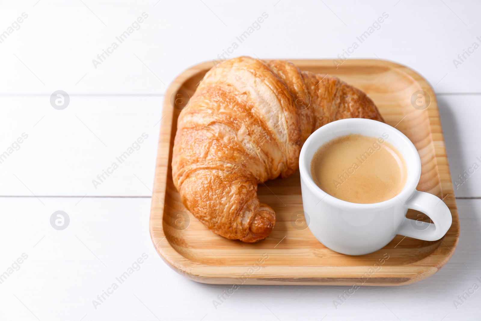 Photo of Breakfast time. Fresh croissant and coffee on white wooden table. Space for text