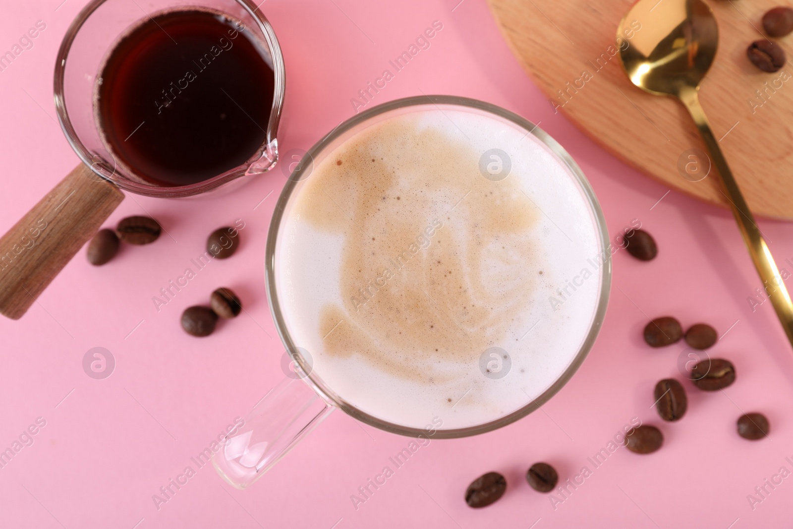 Photo of Cup of fresh coffee and beans on pink table, flat lay