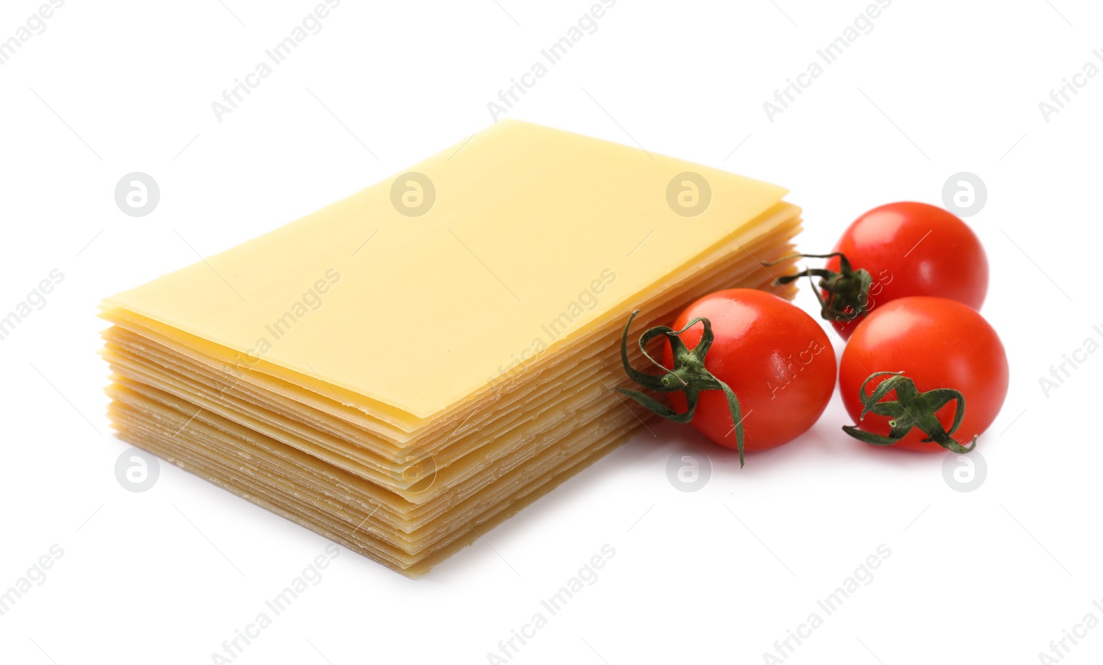 Photo of Stack of uncooked lasagna sheets and tomatoes isolated on white