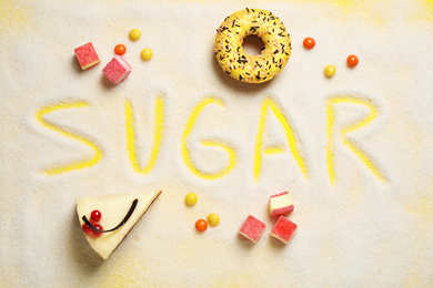Flat lay composition with sweets and word SUGAR on yellow background