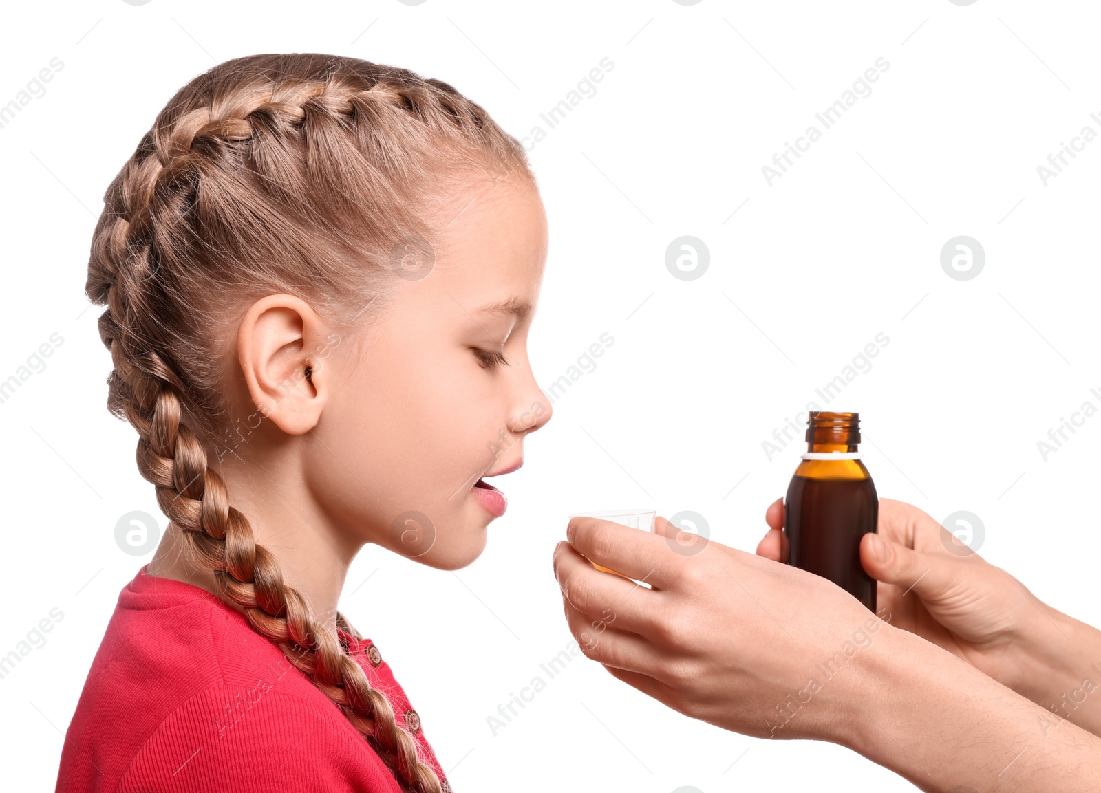 Photo of Mother giving syrup to daughter from measuring cup against white background