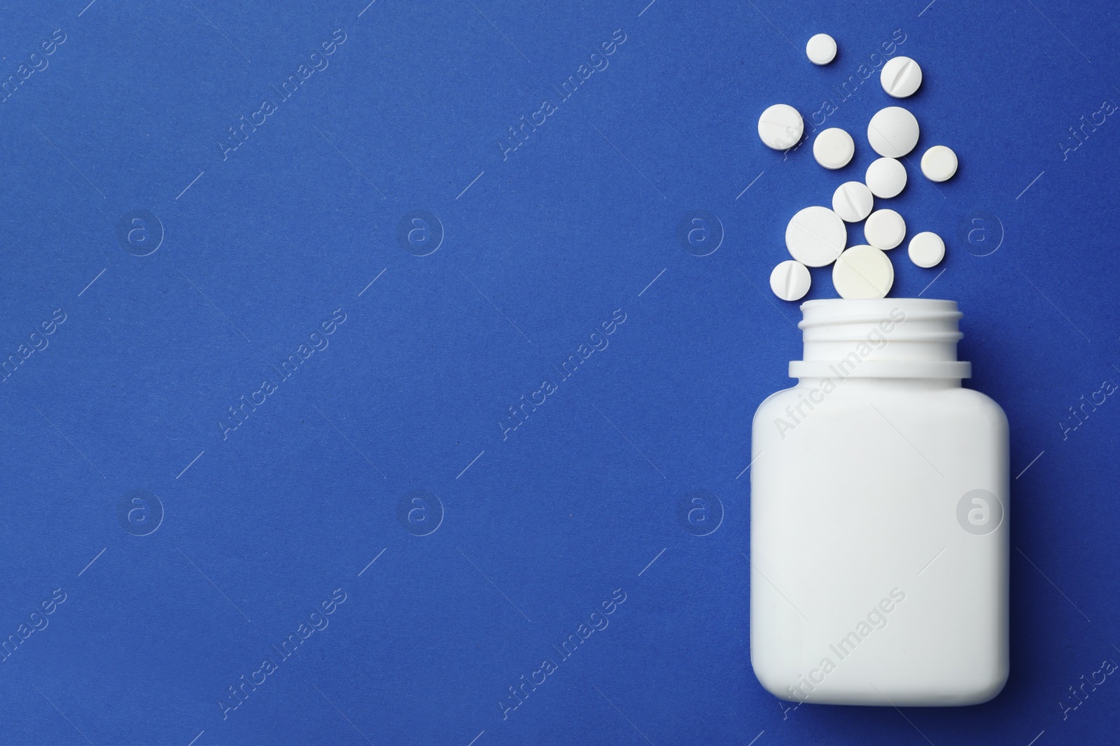 Photo of Bottle with different pills on color background, flat lay. Space for text