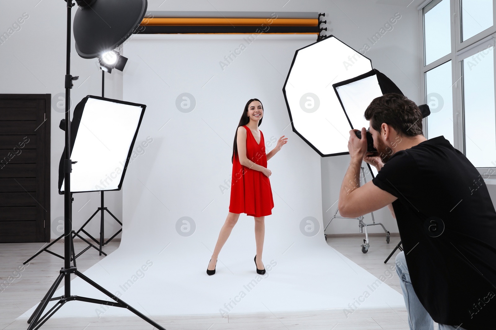 Photo of Beautiful young model posing for professional photographer in studio