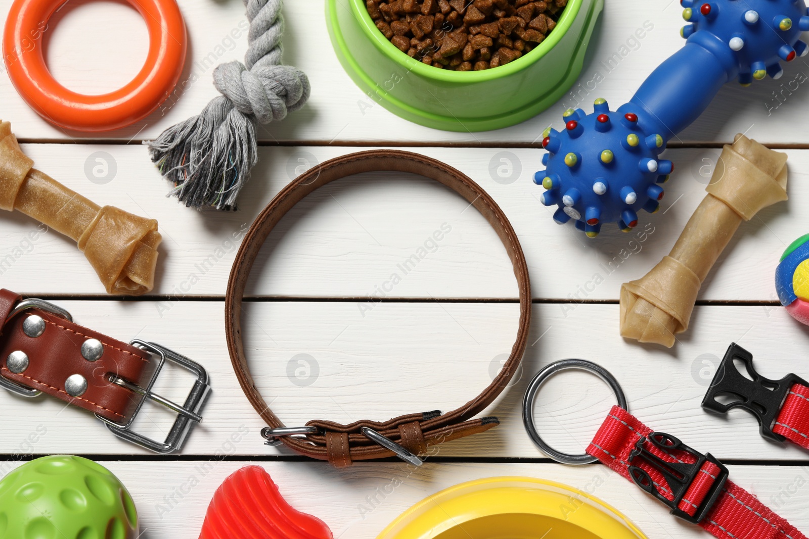 Photo of Flat lay composition with dog collar, toys and food on white wooden table