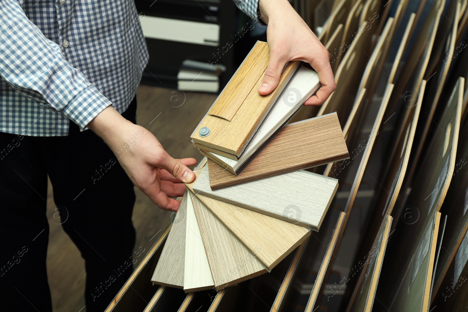 Photo of Man with samples of wooden flooring in shop, closeup