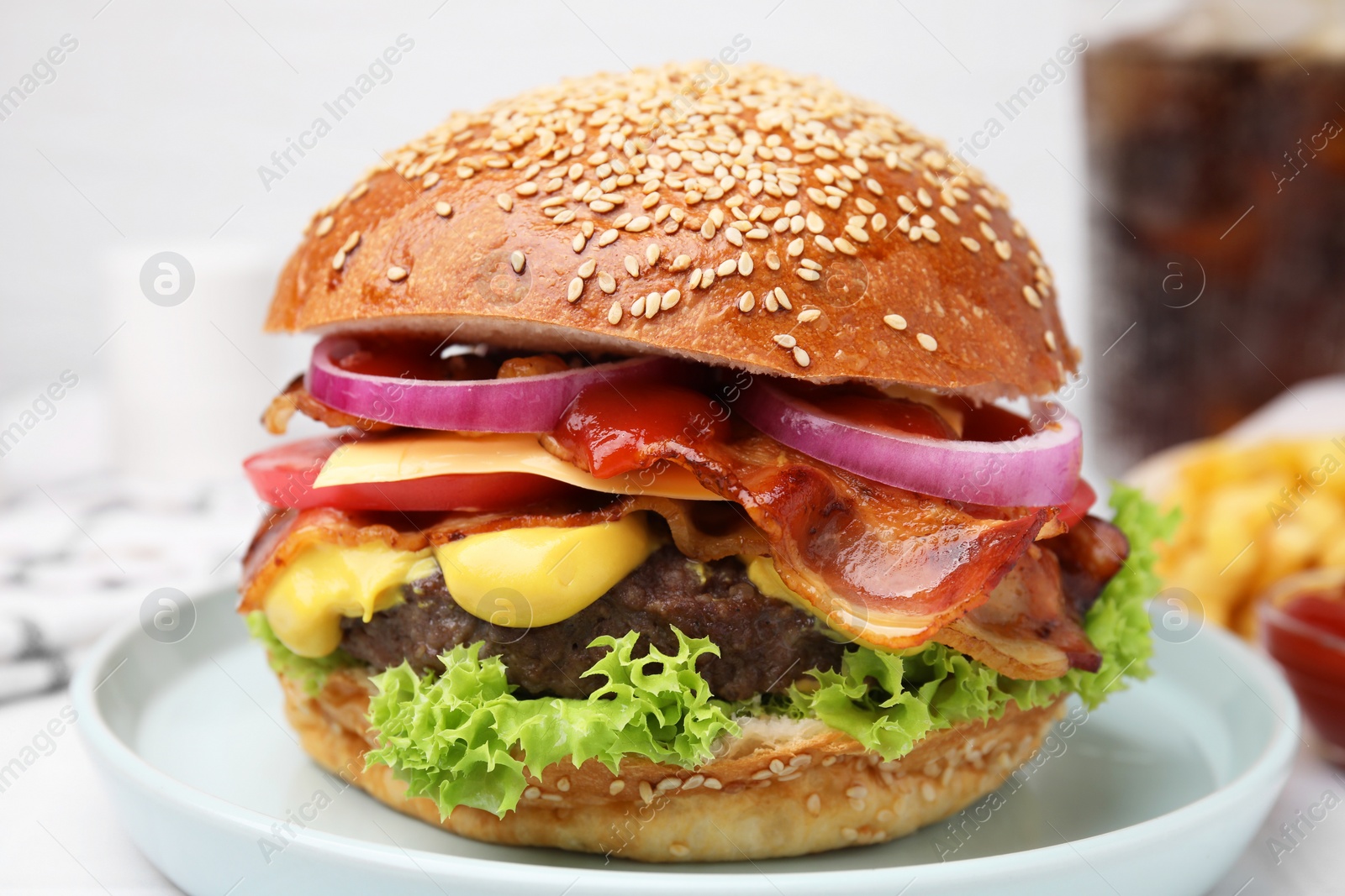 Photo of Delicious burger with bacon, patty and vegetables on table, closeup