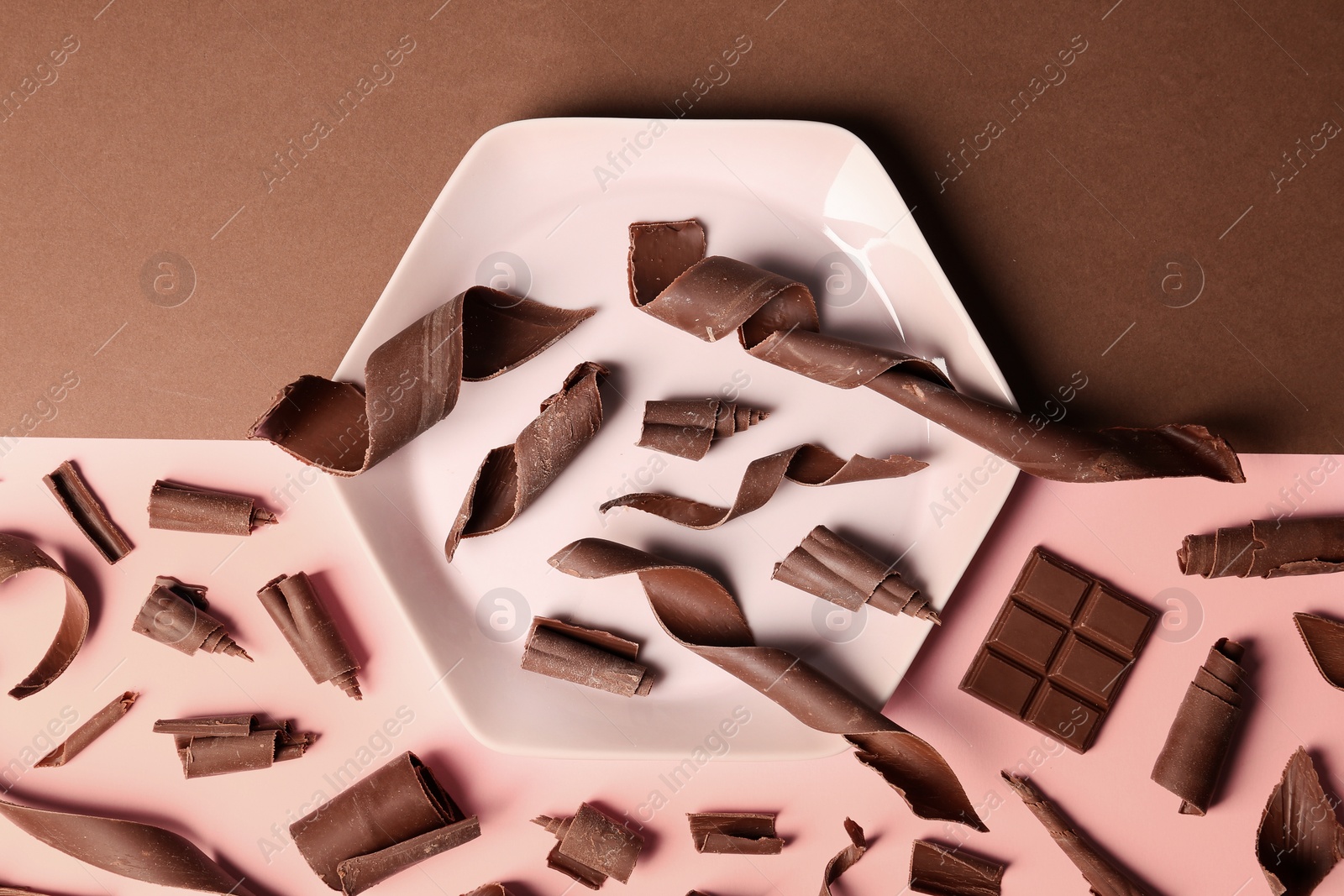 Photo of Flat lay composition with chocolate curls on color background