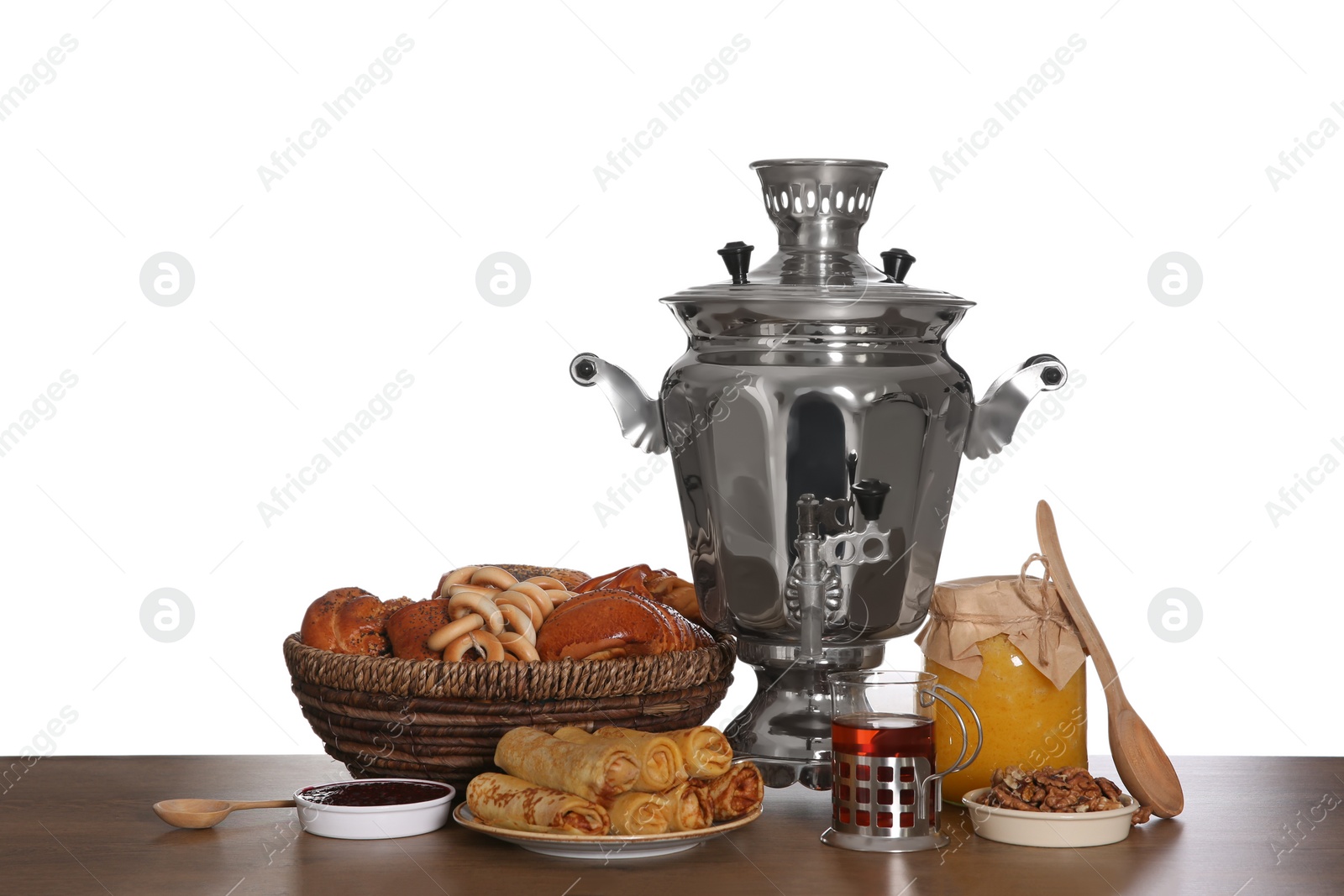 Photo of Traditional Russian samovar with treats on wooden table against white background