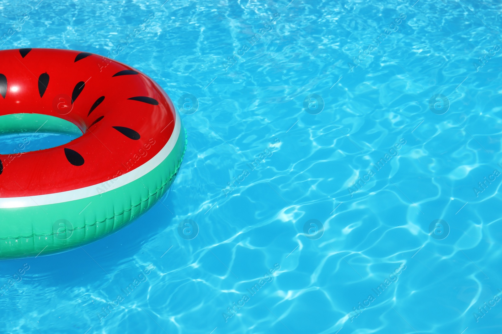 Photo of Inflatable ring floating in swimming pool on sunny day. Space for text