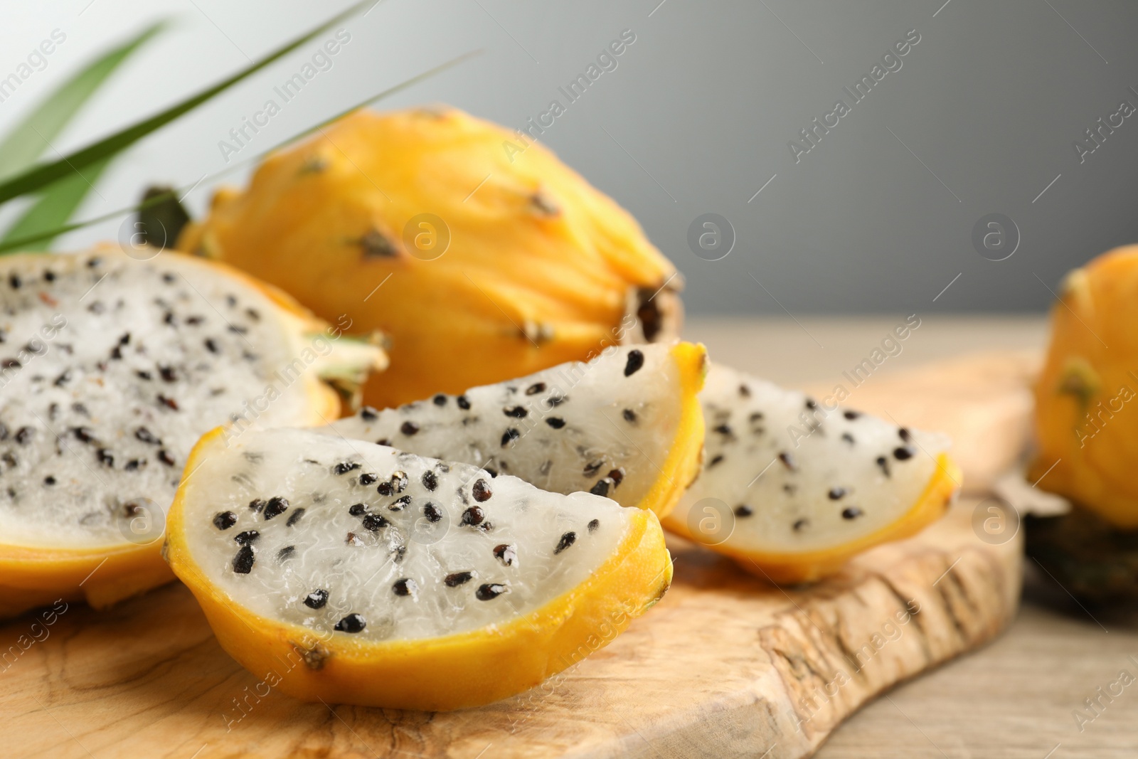 Photo of Delicious cut dragon fruit (pitahaya) on wooden board, closeup. Space for text