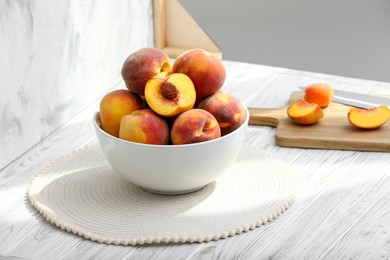 Photo of Bowl of juicy peaches and double-sided backdrop in photo studio