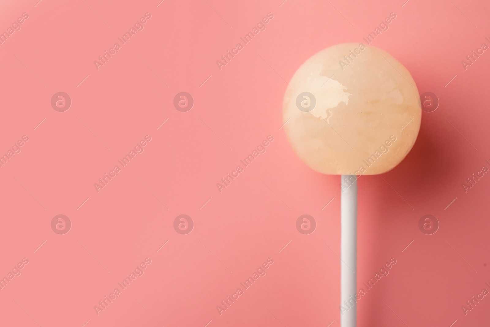 Photo of One tasty lollipop on pink background, top view. Space for text