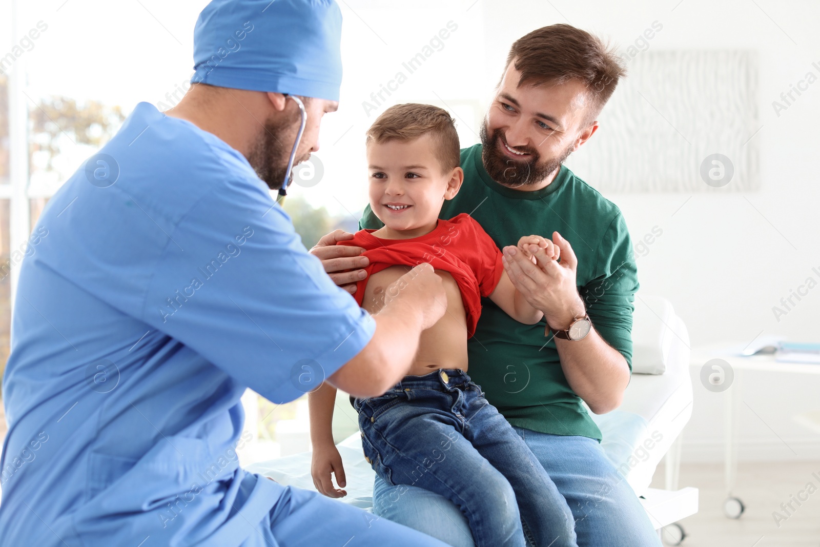 Photo of Children's doctor examining little boy with stethoscope in hospital