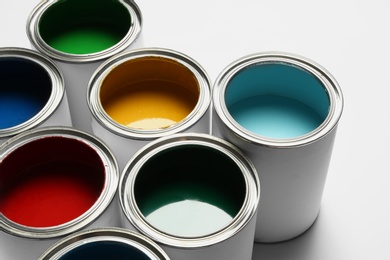 Photo of Many open paint cans on white background