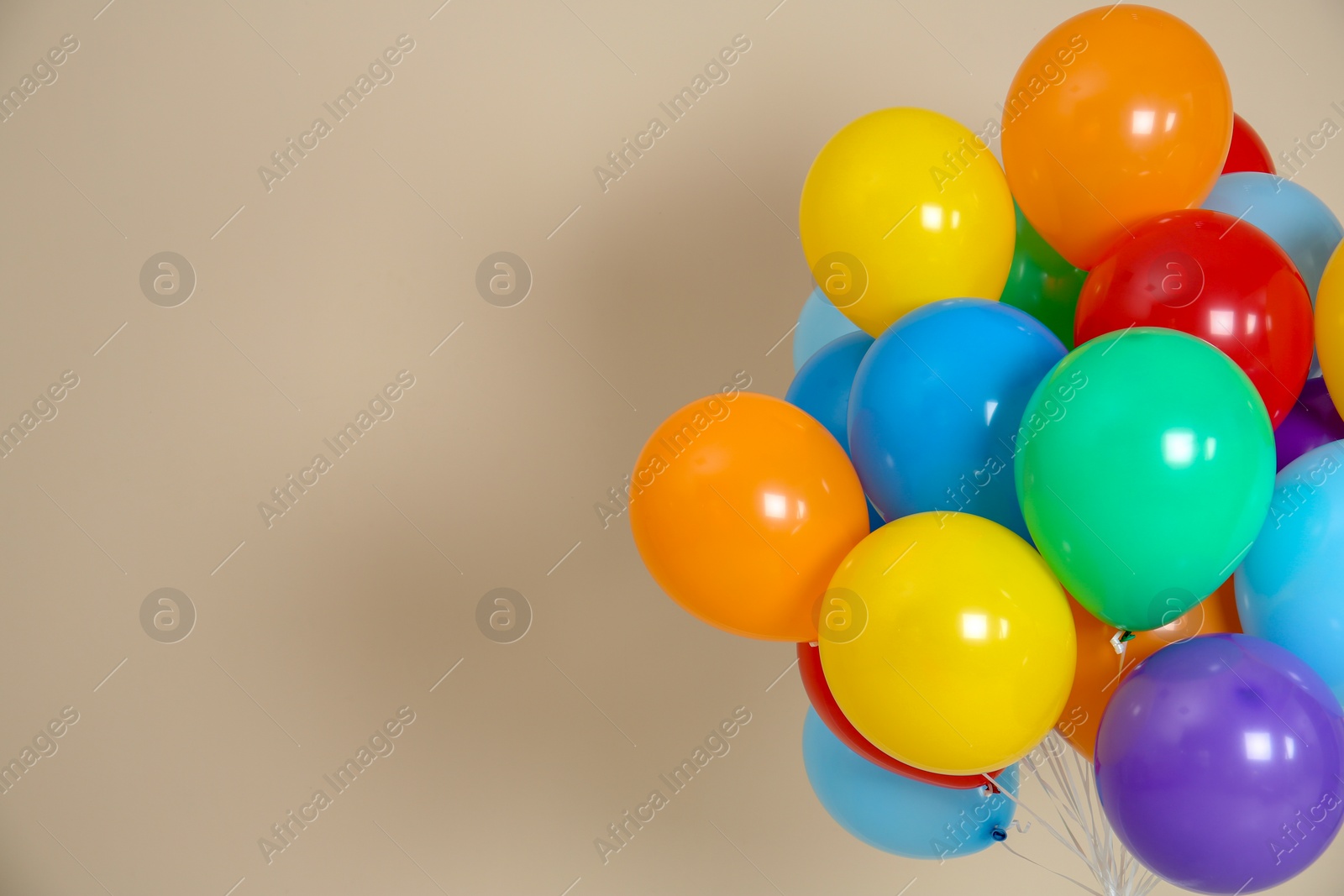 Photo of Bunch of bright balloons and space for text against color background