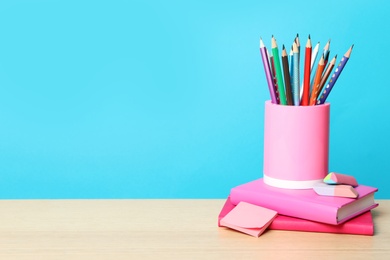 Photo of Composition with different school stationery on wooden table against light blue background, space for text. Back to school