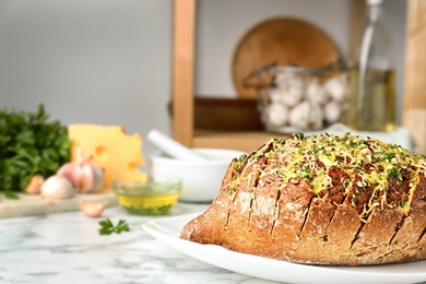 Photo of Tasty homemade garlic bread with cheese and herbs on marble table. Space for text