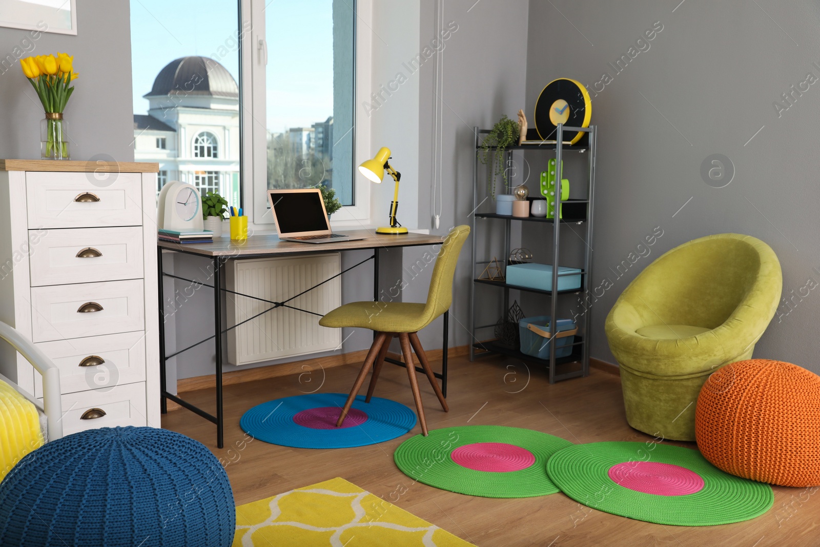 Photo of Comfortable workplace with modern laptop near window in child room. Interior design