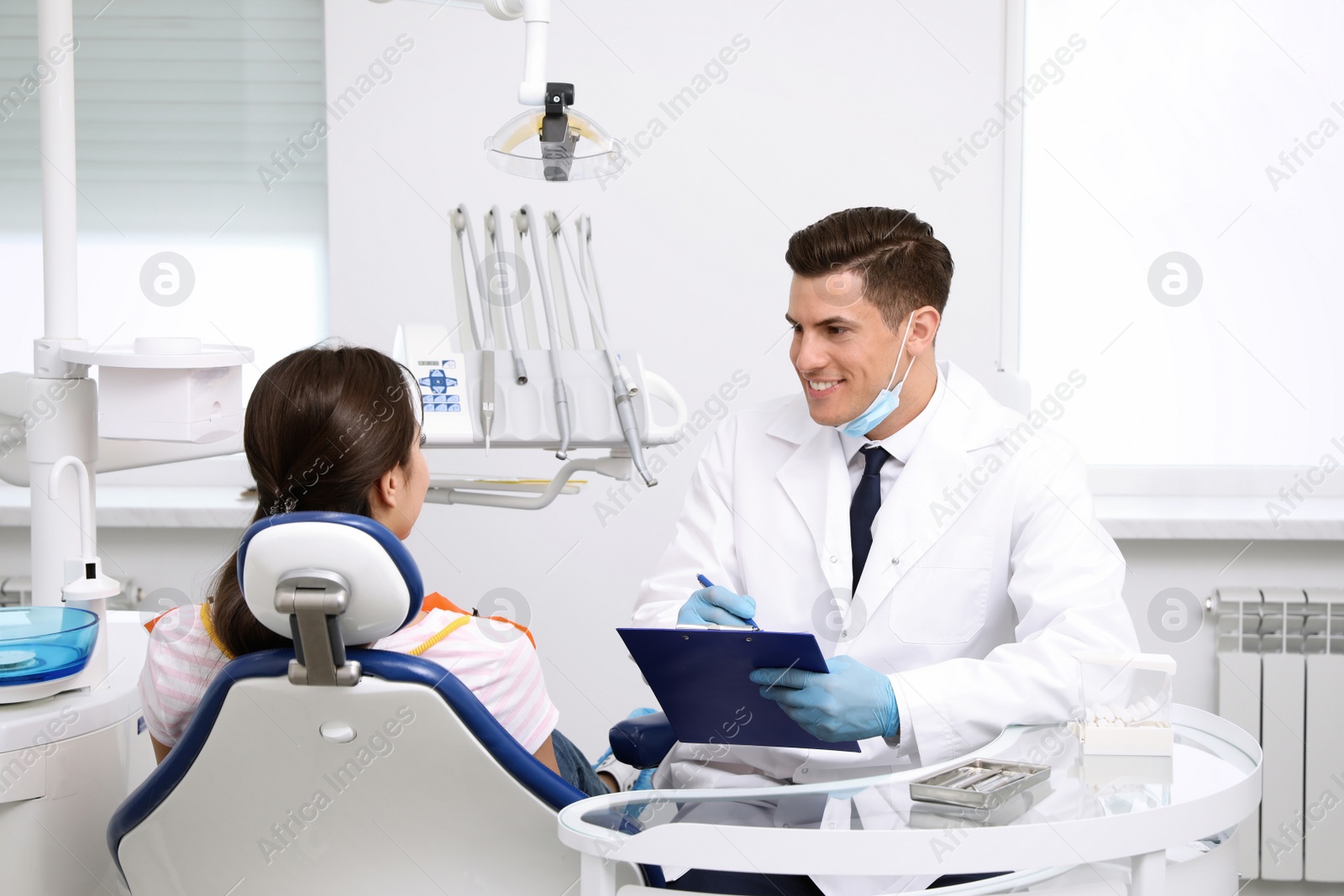 Photo of Professional dentist working with patient in clinic