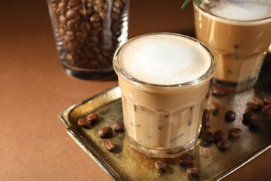 Photo of Refreshing iced coffee with milk in glasses on brown table, closeup