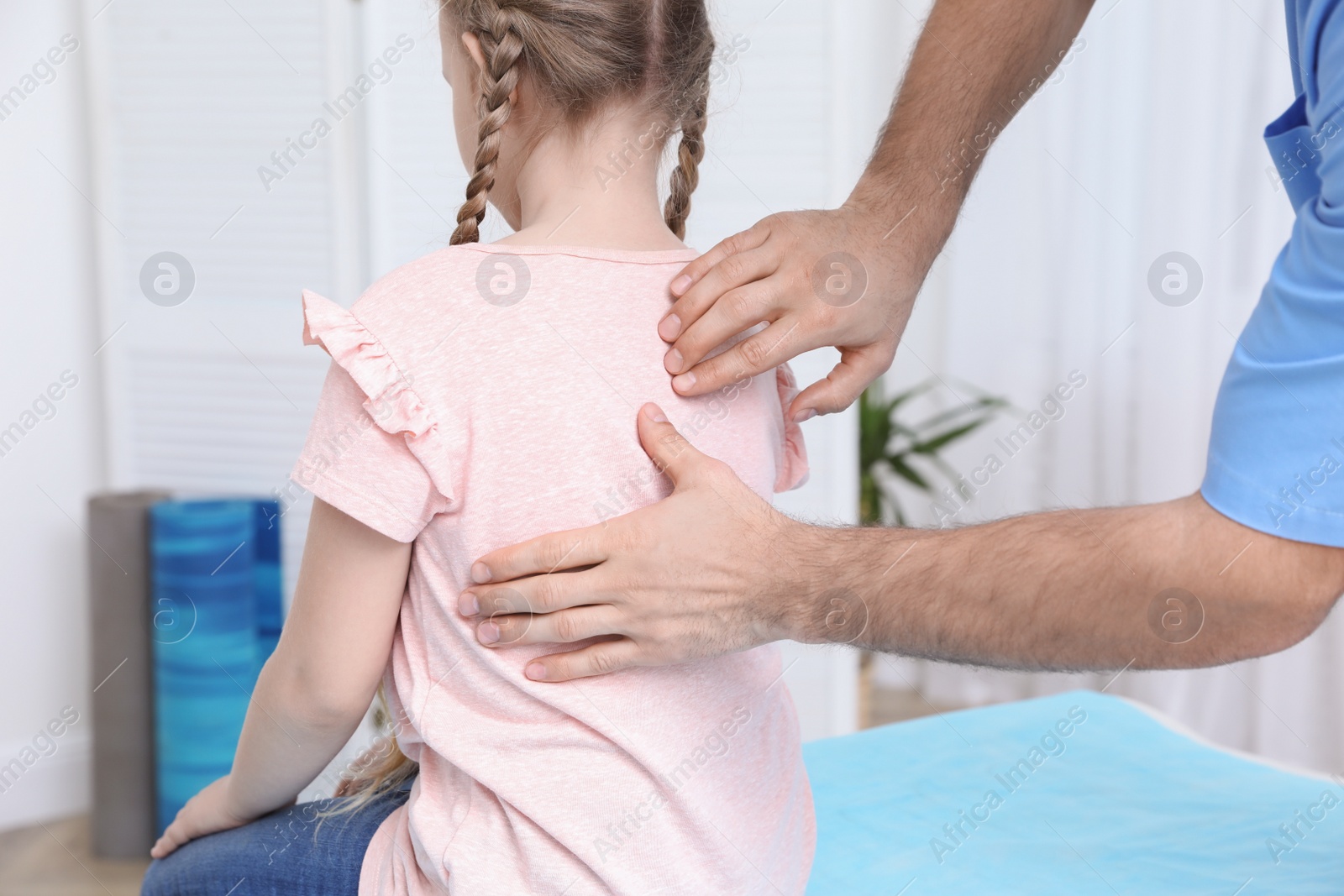 Photo of Orthopedist examining child's back in clinic, closeup. Scoliosis treatment