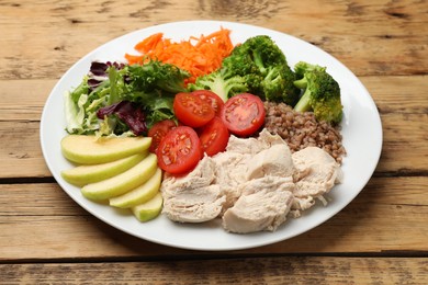 Photo of Balanced diet and healthy foods. Plate with different delicious products on wooden table